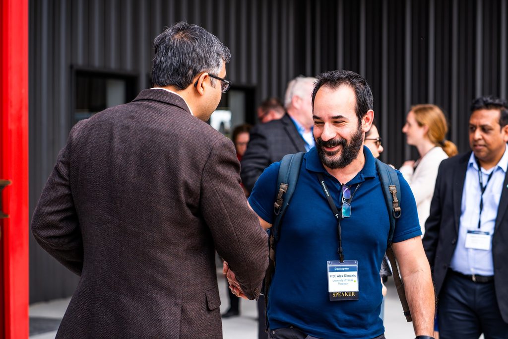 Prof. Alex Dimakis from The University of Austin meeting with delegates during the networking session.