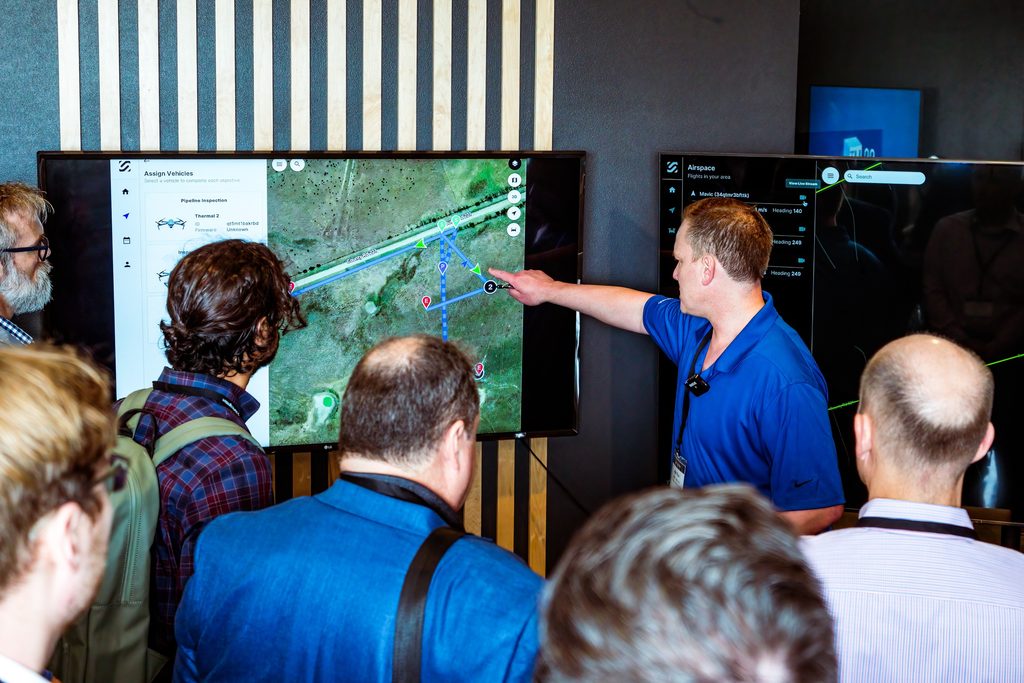 SkyGrid is a Boeing/SparkCognition joint venture focused on the safe integration of large volumes of Unmanned Aerial Vehicles in the airspace. Here, attendees are witnessing a live demonstration of a fleet of drones orchestrated and monitored via the SkyGrid platform.